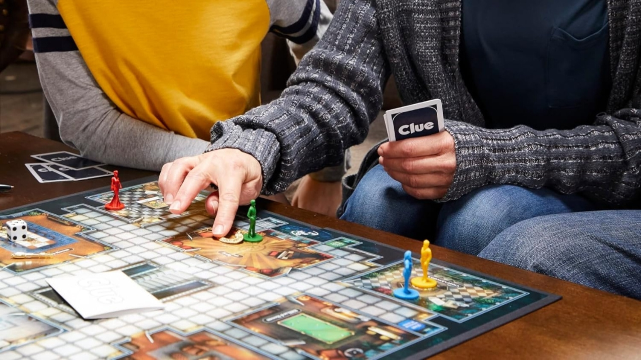 A young child and parent playing Clue together. 