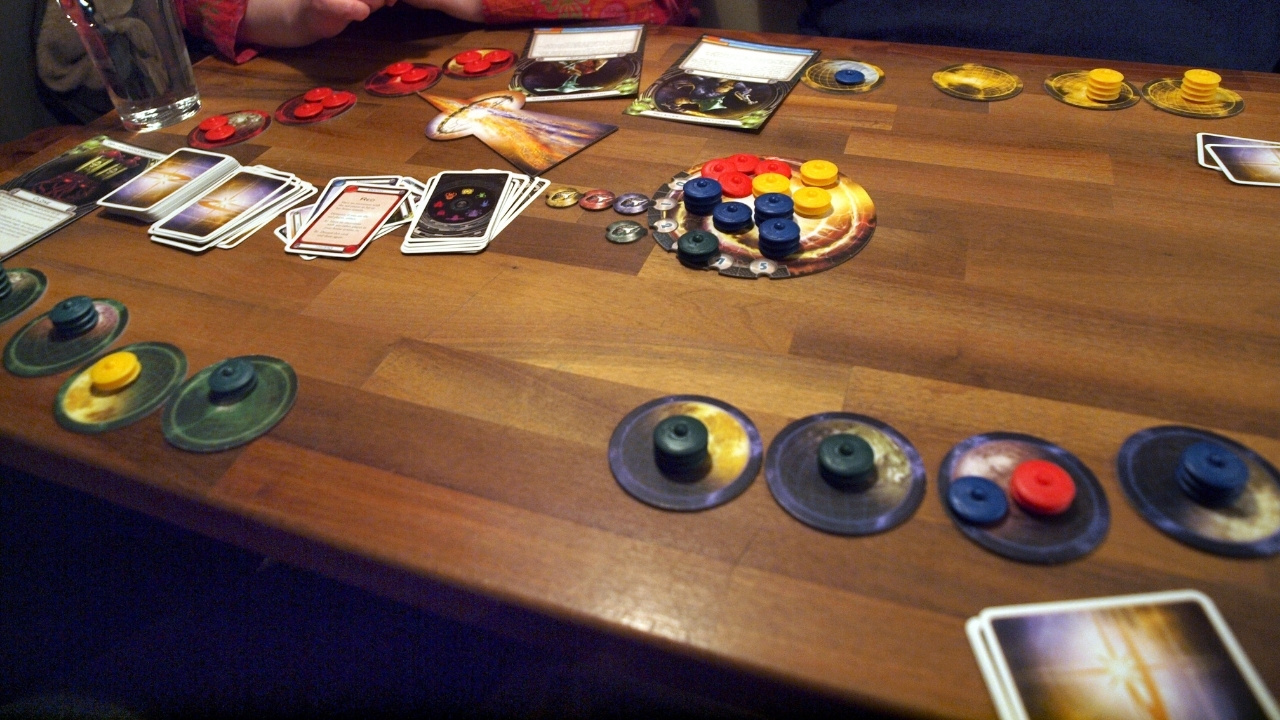 A game of Cosmic Encounter being played by a small group on a wooden table. 