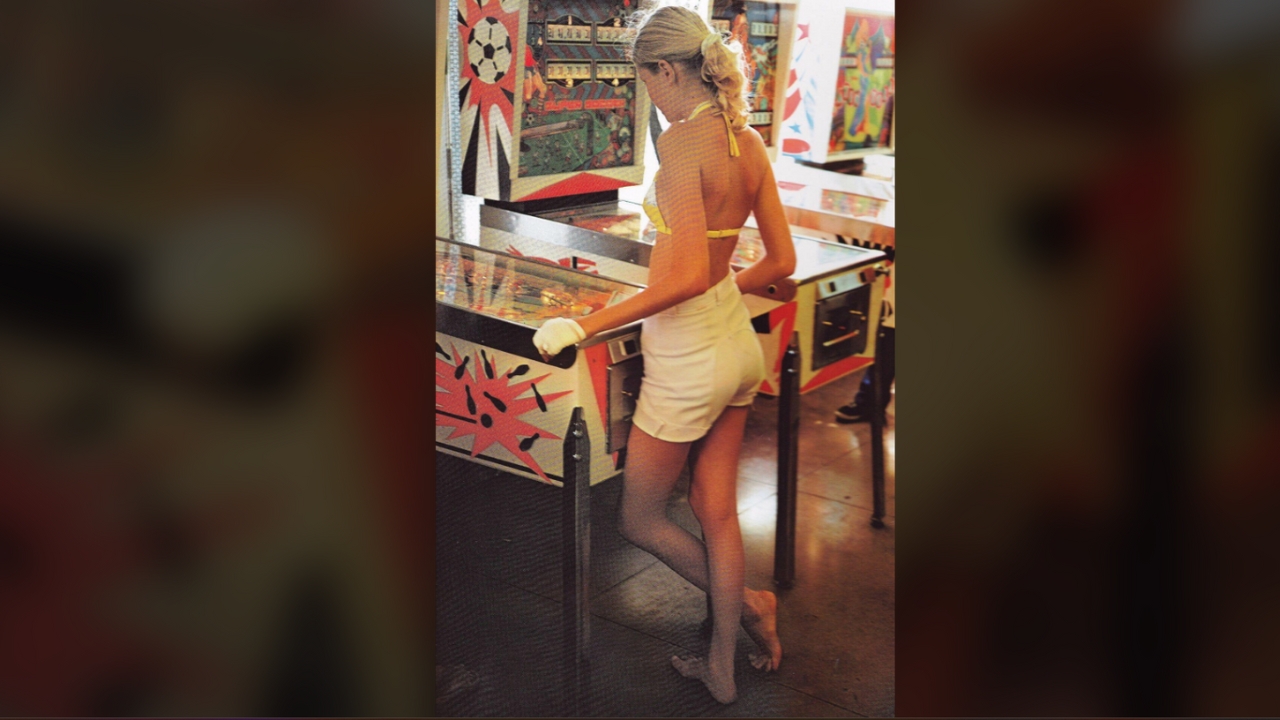 Vintage woman playing pinball