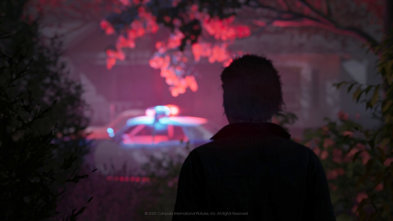 Michael Myers stands in foreground, looking toward a police car's flashing lights.