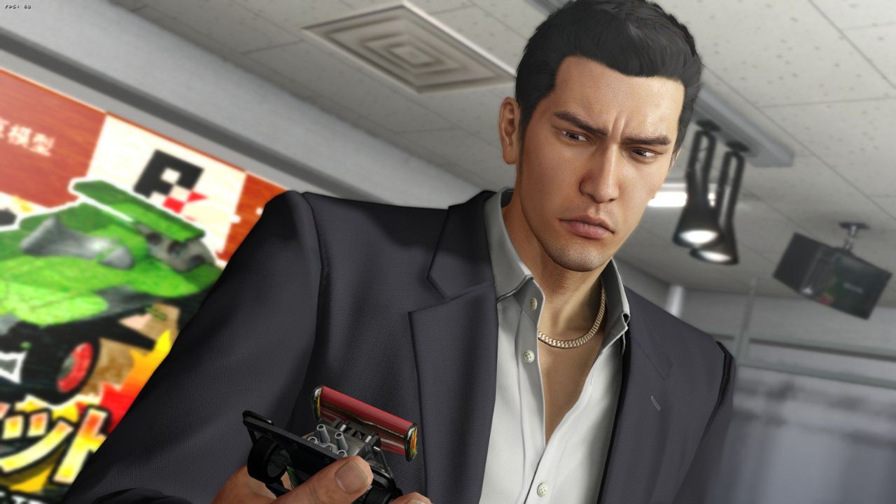 Kiryu furrows his brow as he looks at his out-of-order slot car.